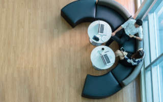 Dos empleados hablando mientras están sentados sobre muebles modulares